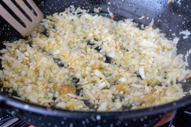 istock Homemade Aromas: Preparing Onion and Garlic Sofrito in Pan with Wooden Spoon. 2154154347