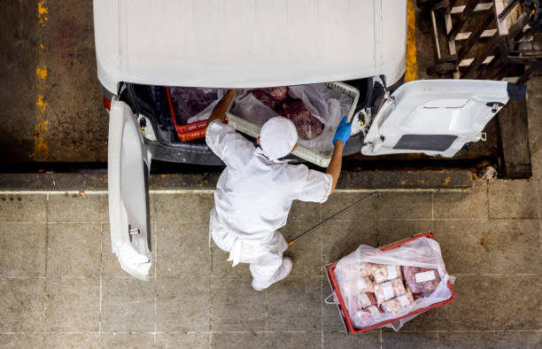 Employee loading meat on a van for delivery at a butcher's shop