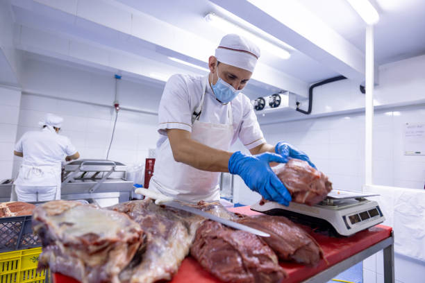 istock Butcher cutting meat and weighing it on the scale 2154154927