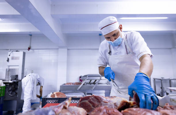 istock Butcher cutting meat while working at a butcher's shop 2154154930