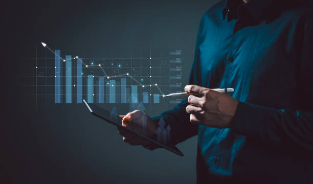 istock Businessman holds a tablet with augmented reality holographic statistics. Graphs and Targets Developing a growing business strategy and growth plan Investing in Currency Rate Growth 2154155050