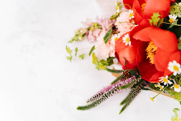 Beautiful bouquet with red peony and other flowers on white table with copy space for your text top view and flat lay style