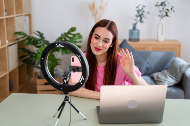 istock Female vlogger recording video content with smartphone and ring light 2154156886