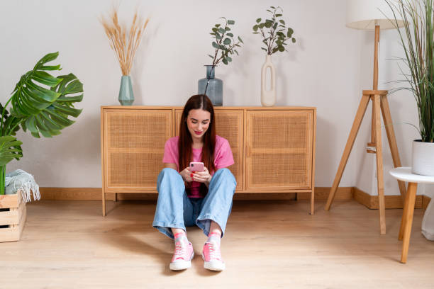 istock Young woman using smartphone at home 2154157169