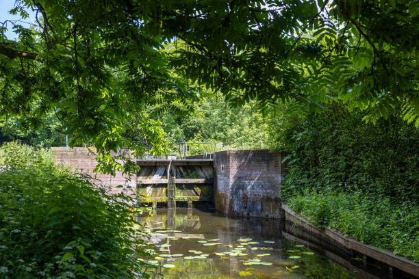 istock Canal and small lock with closed lock doors in a beautiful green area on a sunny day 2154157710
