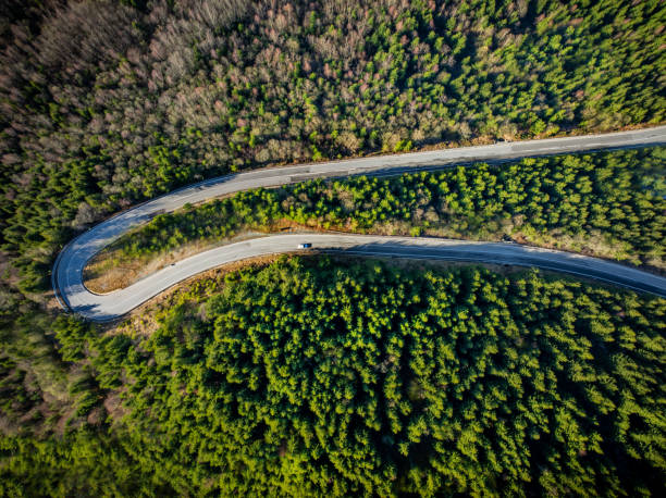 istock Winding serpentine road in the mountains meanders through the lush greenery, weaving its way through a dense forest. 2154165076