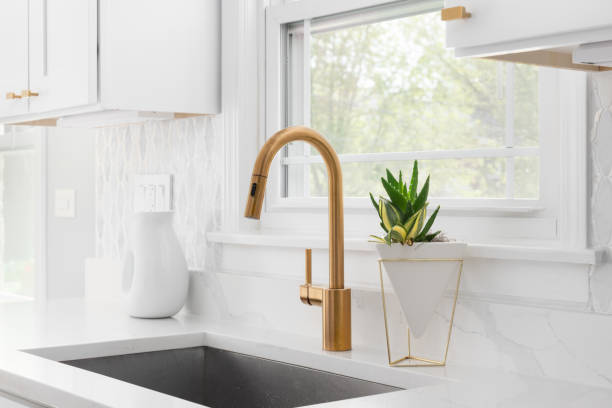 istock A gold kitchen faucet detail with white cabinets. 2154172608