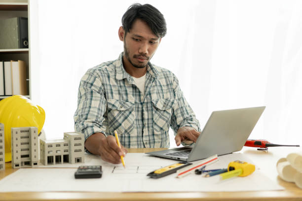 istock Architects studying floor plans, serious civil engineers working with documents on real estate construction, and professional foremen in home improvement: 2154173787