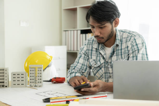 istock Architects studying floor plans, serious civil engineers working with documents on real estate construction, and professional foremen in home improvement: 2154173789
