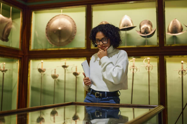 istock Woman visitor in the historical museum looking at art object. 2154176227
