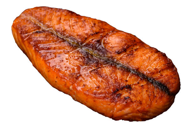 Fresh cooked delicious salmon steak with spices and herbs baked on a grill. Healthy seafood food