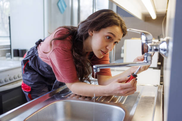istock Repairwoman using a screwdriver to fix kitchen faucet 2154180358