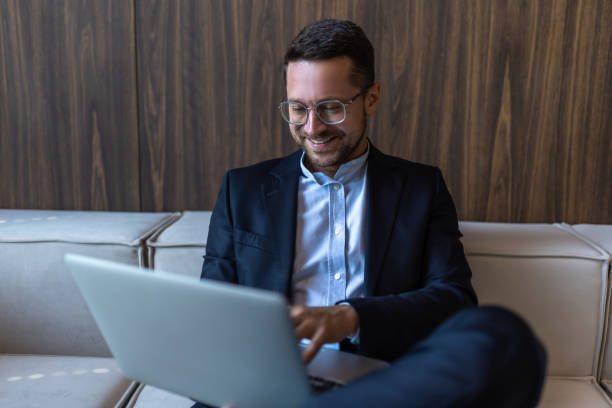 istock Confident businessman in glasses working on laptop computer in office interior 2154180739