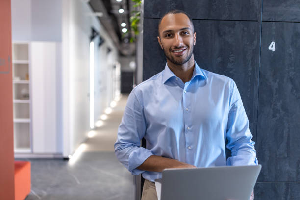 istock Confident businessman in office hall with laptop 2154180931
