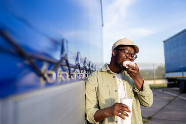 istock Professional driver eating fast food at truck stop. 2154181638