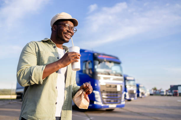istock Truck driver holding lunch at truck stop. 2154181782