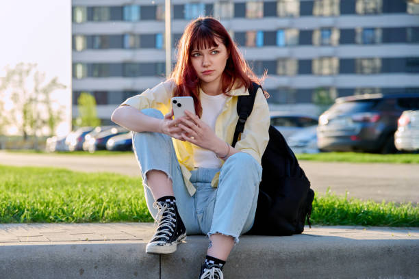 istock Young beautiful woman using smartphone, sitting on floor, urban style 2154184361
