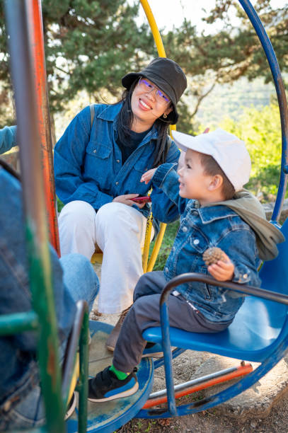 istock mother and her young son share a joyful moment on a carousel ride 2154184781