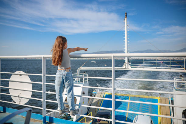 Little girl is on a ship, boat or ferry. Little girl learning out of the stern of a ship. ferry deck girls stock pictures, royalty-free photos & images