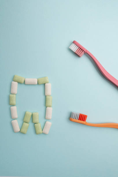 istock Toothbrush and chewing gum lie on a colored background. Time to brush your teeth. Top view, flat lay. Dental health concept 2154186884