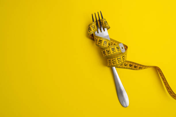 istock Yellow measuring tape on a light background. Tool for measuring length and volume. Tape for measuring in the clothing industry or the volume of the human body 2154187148