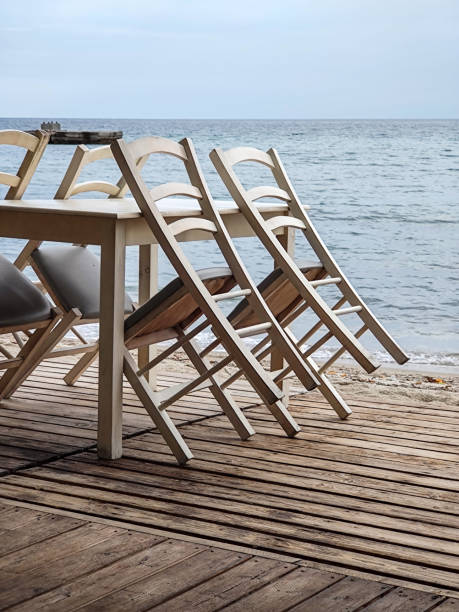 Table and chairs ready for new guests by the sea in a typical Greek taverna