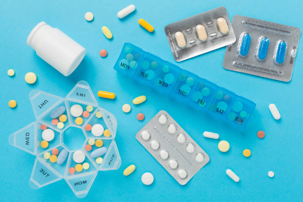 istock Daily pill organizer with medications on color background, top view 2154188927