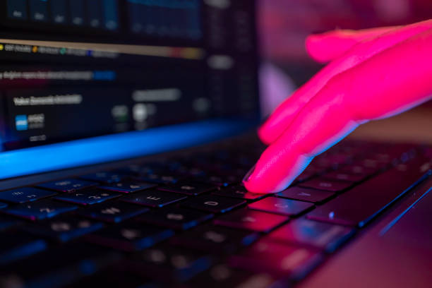 istock Woman's hand typing on computer keyboard in the dark, working late on laptop at home 2154189926