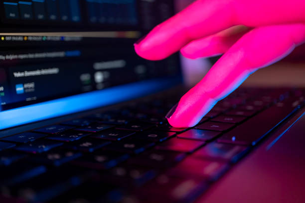 istock Woman's hand typing on computer keyboard in the dark, working late on laptop at home 2154189964