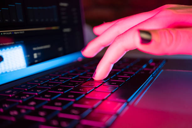 istock Woman's hand typing on computer keyboard in the dark, working late on laptop at home 2154189969