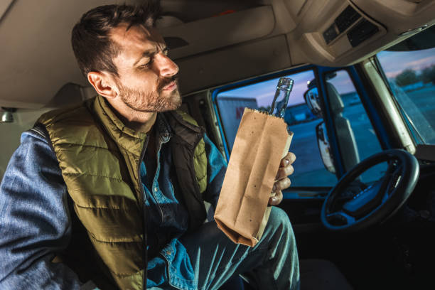 istock Young handsome man driving long vehicle, taking a break from long ride and drinking some alcohol. 2154190082