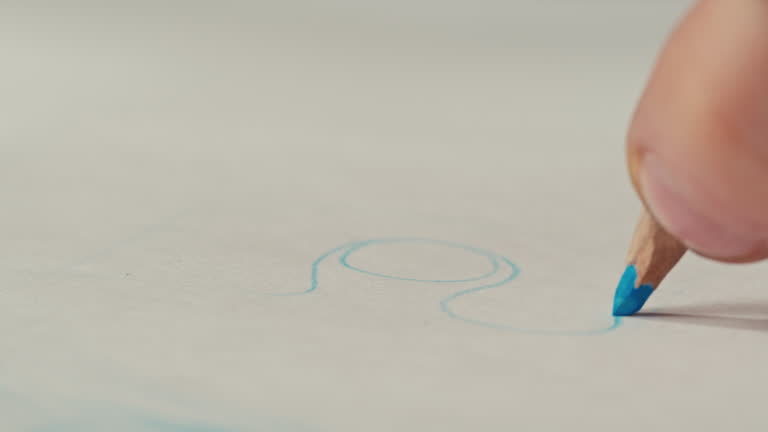 Close-up of blue colour pencil drawing on white paper macro. The designer making sketches for the projection of furniture close-up. Drawing and sketching lessons concept.