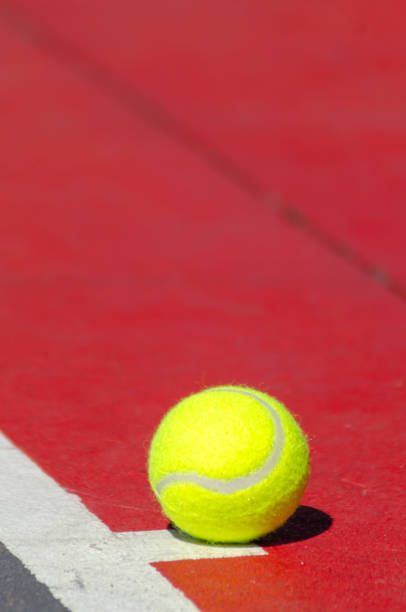 a ball on a red hard surface tennis court