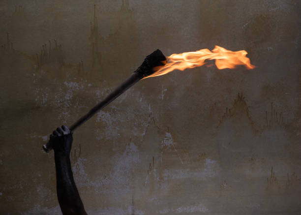 flame and burning wick on an oil torch against an overcast sky