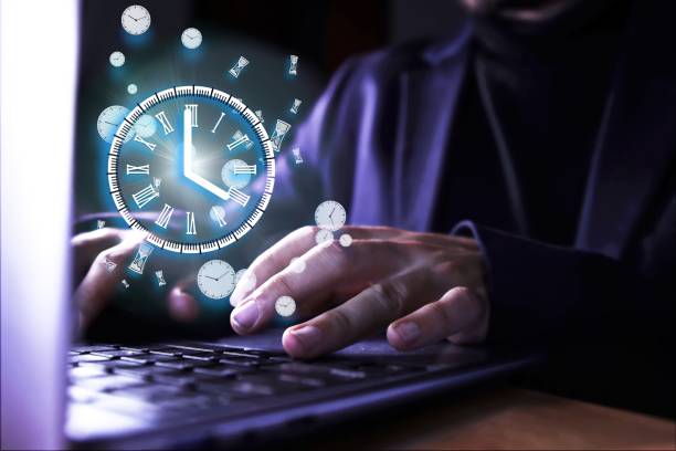 istock Image of a man using the computer with a clock indicating the time of use of the pc. Abusive use of the computer. 2154197293