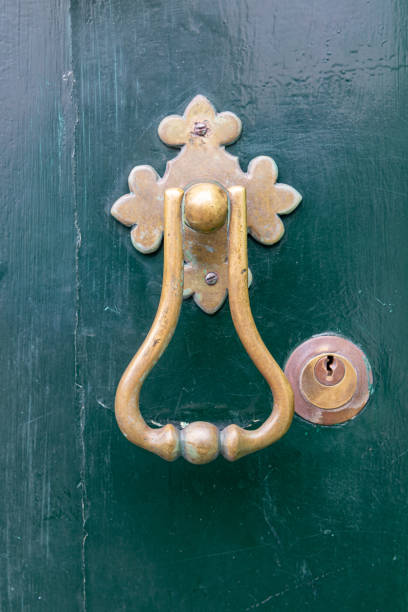 istock An old brass door knocker on a green door. 2154197805