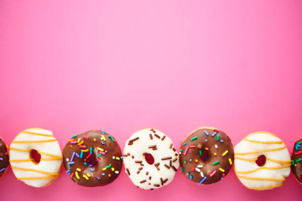 istock A variety of donuts on a bright pink background with space for text 2154198910