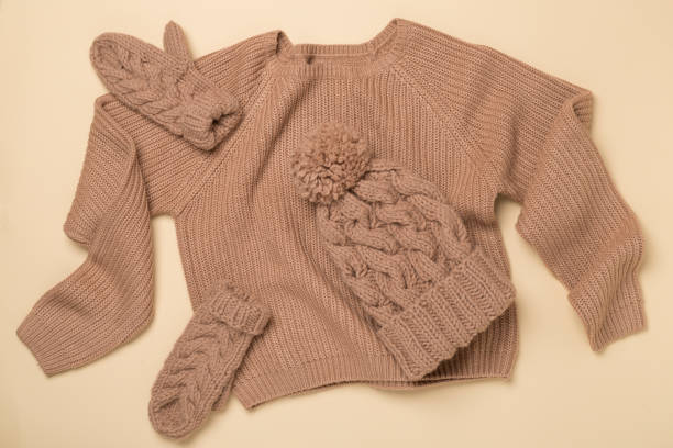 istock Sweater and winter hat with mittens on color background, top view. 2154199682