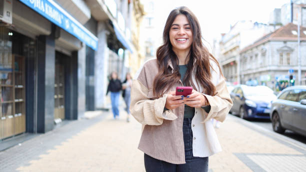 istock Happy Latin woman texting on the move 2154199893