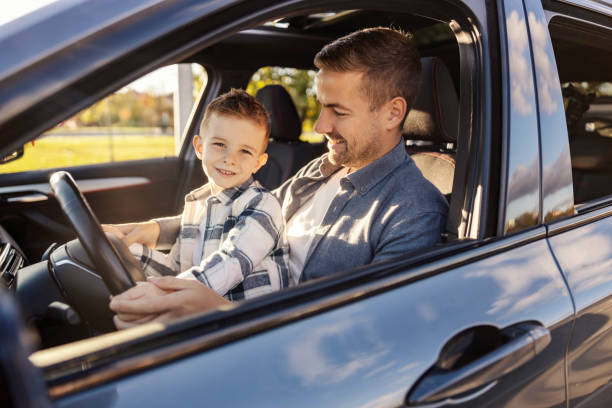 istock A dad is teaching his child how to drive a car. 2154202492