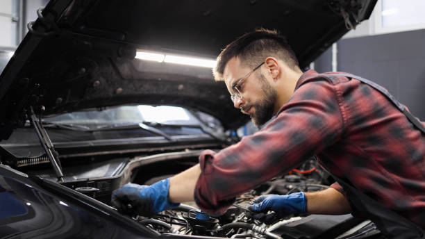 istock Young auto mechanic working at his car repair service 2154207013