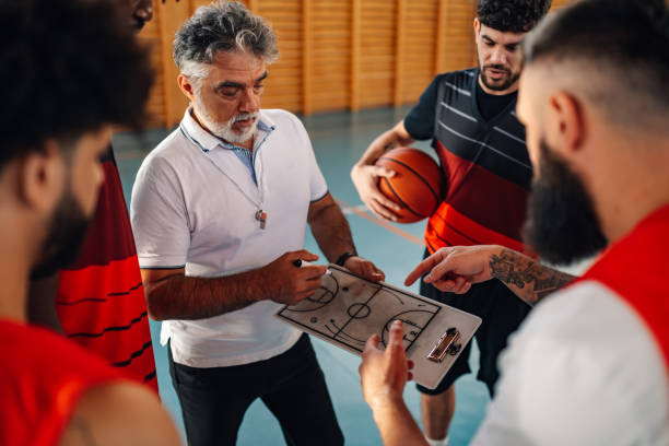 istock Mature basketball coach and his diverse team having a team talk during practice 2154211901