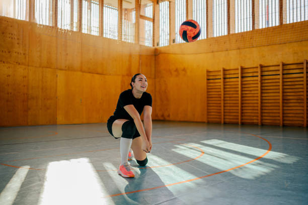 istock Woman volleyball player kneeling while receiving a ball with a bump 2154211911