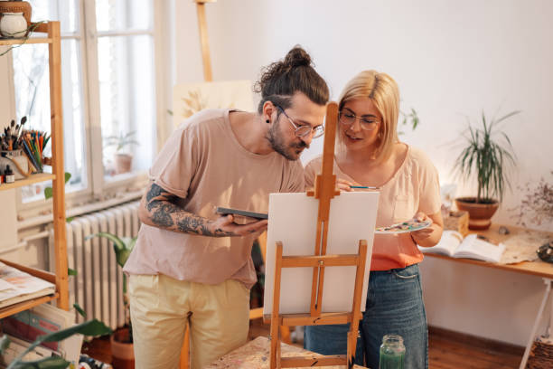 istock Focused artistic couple painting together on easel at creative art studio 2154211954