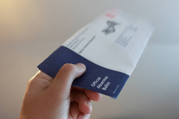 istock Voter Holds an Absentee Voting Ballot Envelope 2154218956