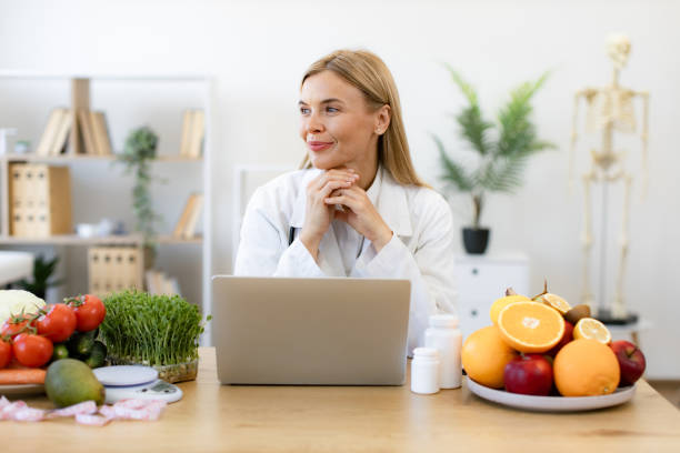 istock Nutritionist working on laptop and writing diet plan for patient. 2154220216