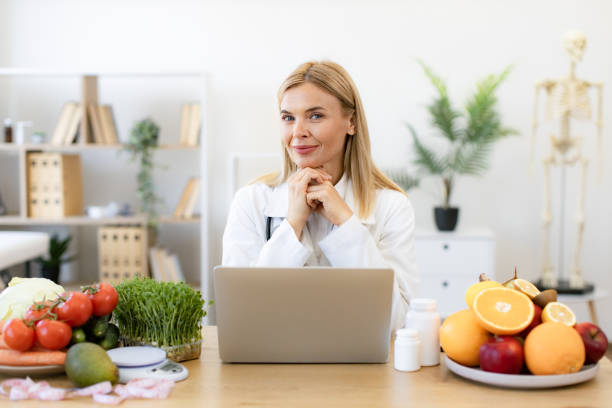 istock Nutritionist working on laptop and writing diet plan for patient. 2154220229