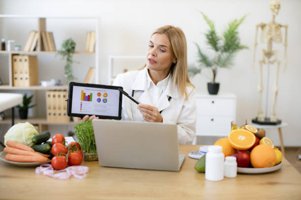 istock Female nutritionist explaining details of slimming program for client online. 2154220885