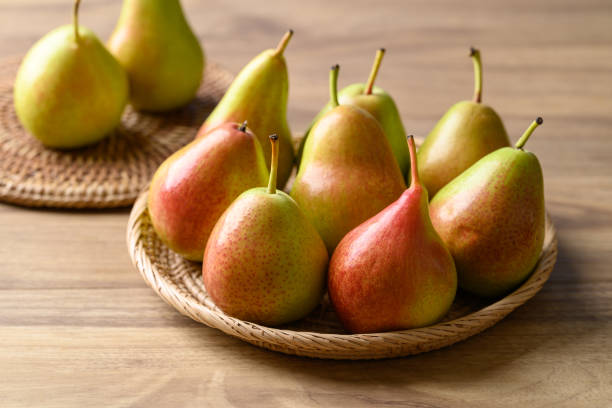 istock Fresh pear fruit in natural basket on wooden background 2154221591