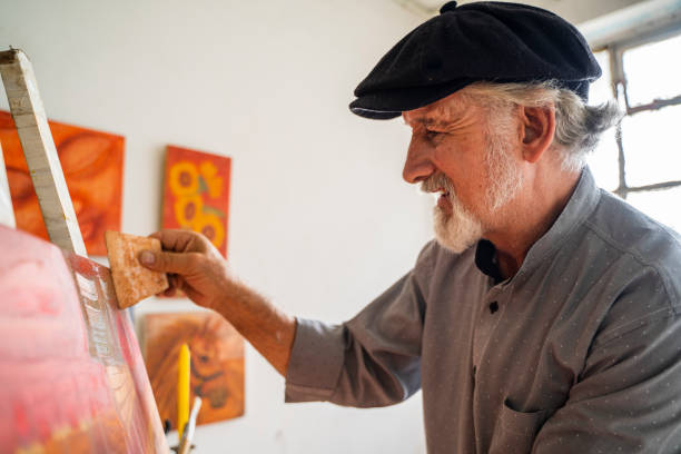 istock Older man passionately and energetically paints a painting for a client 2154226487